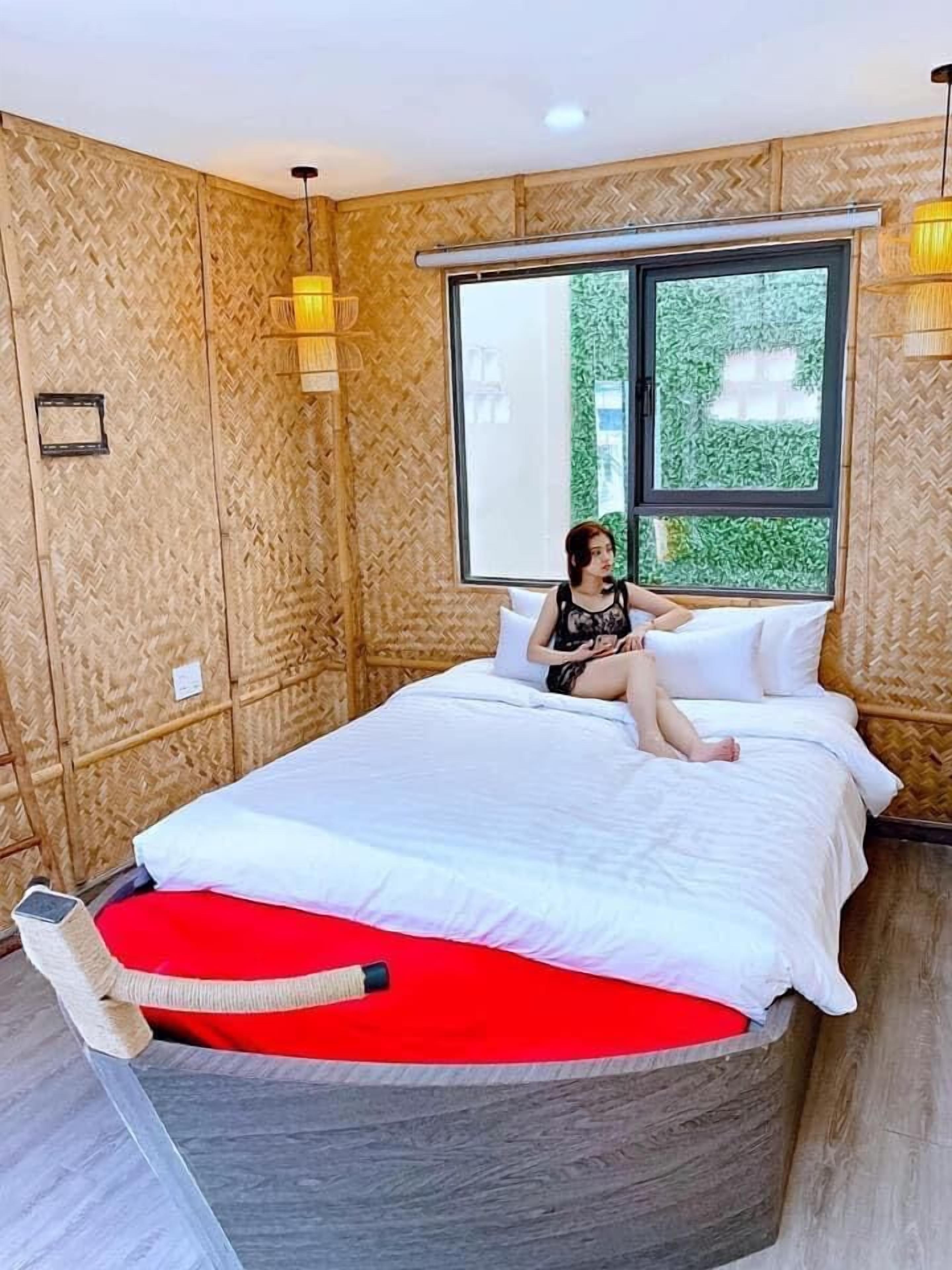 Une pièce avec un lit, une fenêtre et un mur orné d’un motif en chevrons.