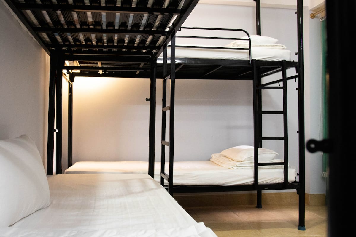 A bunk bed room with a single bed on the left and a bunk bed on the right.