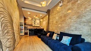 Ein modernes Wohnzimmer mit einem dunkelblauen Sofa, Holzboden und einer Steinwand.