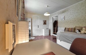 Ett sovrum med en säng, en byrå, en garderob och ett skrivbord.