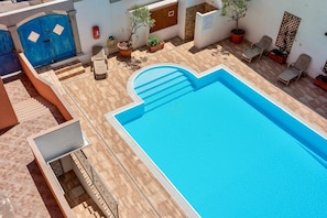 A rooftop swimming pool with a clear blue water, surrounded by potted plants and lounge chairs. - Residence con piscina a 300 mt dal mare (Santa Teresa di Gallura)