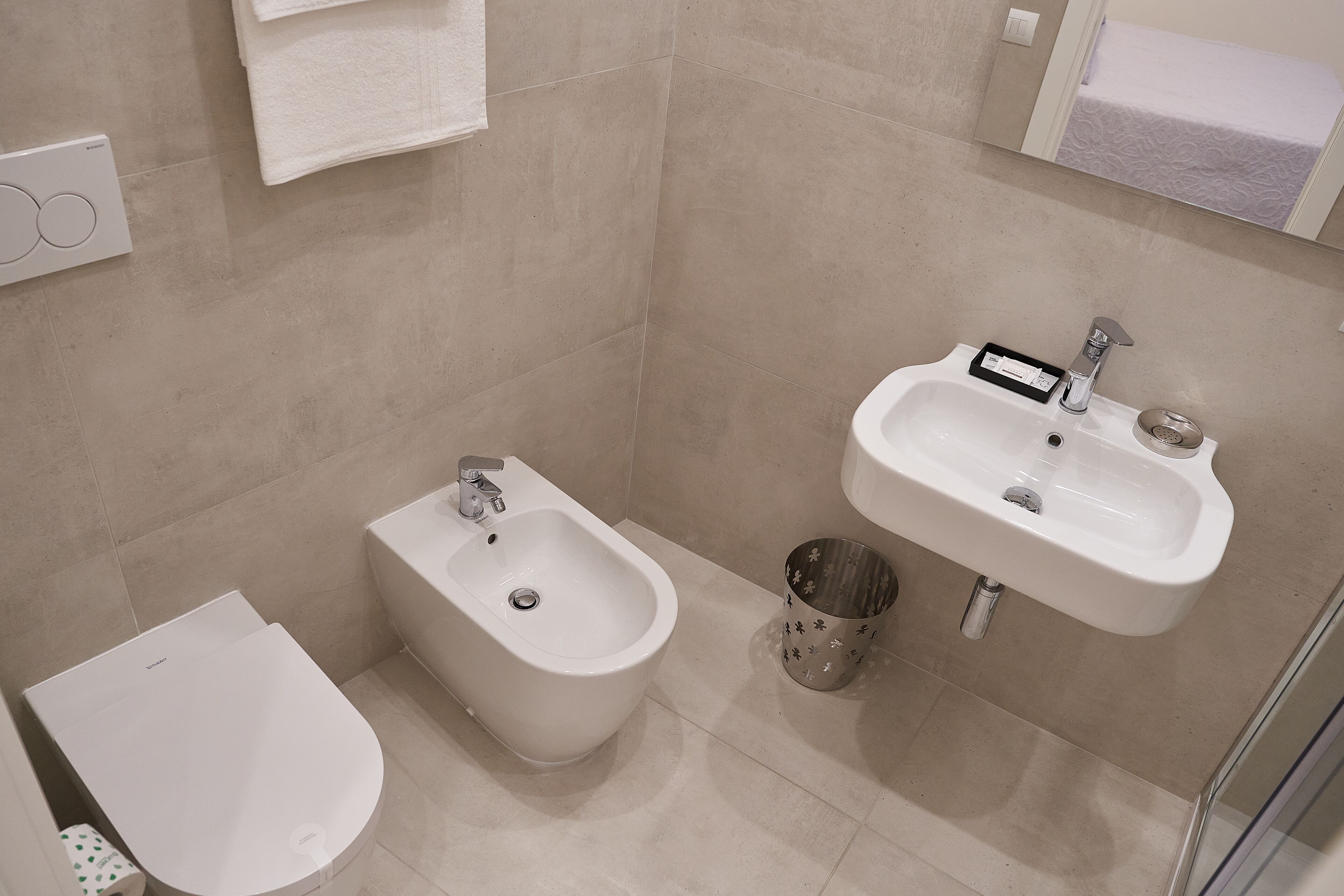 A modern bathroom with a bidet, a sink, and a toilet.
