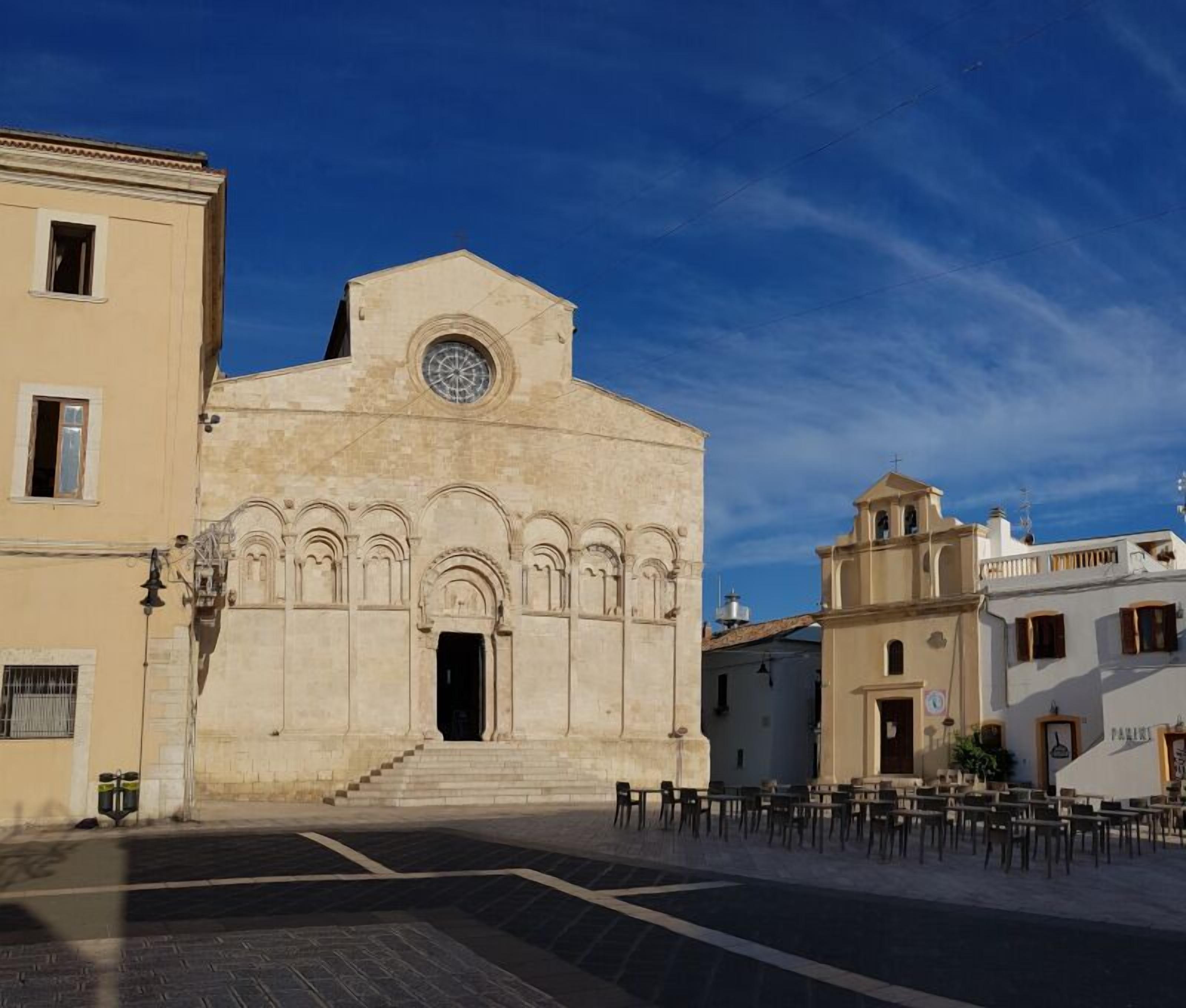 A historic building with a central entrance, a clock, and a bell tower.