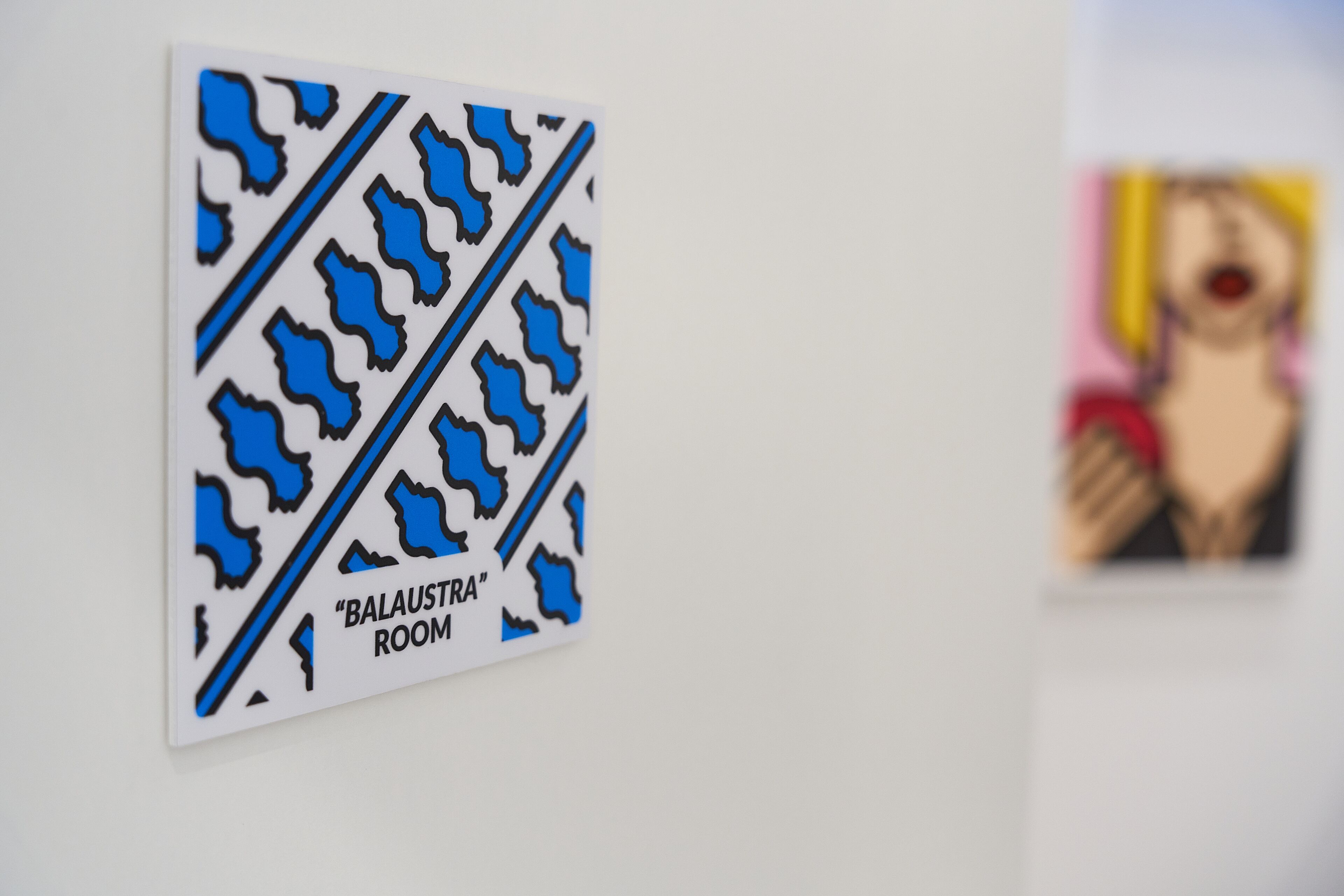 Un letrero montado en la pared con un diseño de formas azules y el texto 