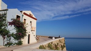 A coastal building with a balcony overlooking the sea, a clear sky, and a view of the ocean. - Glave Rooms (Termoli)