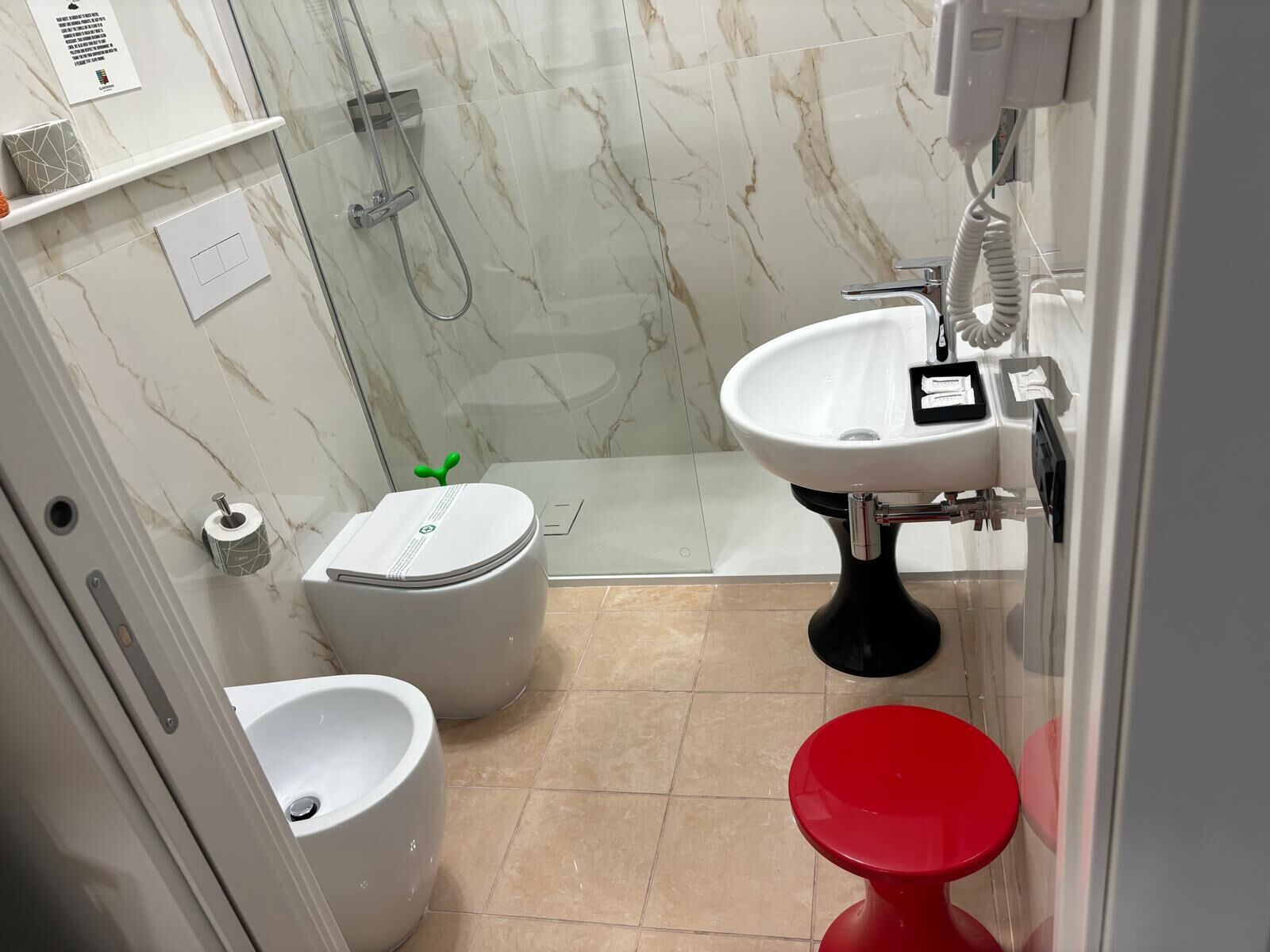 A bathroom with a toilet, bidet, and shower area.