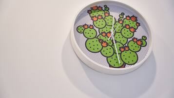 Un reloj de pared con diseño de cactus.