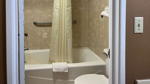 A bathroom with a bathtub, toilet, and shower curtain. - Studio 6 Millington, Tn (Millington)