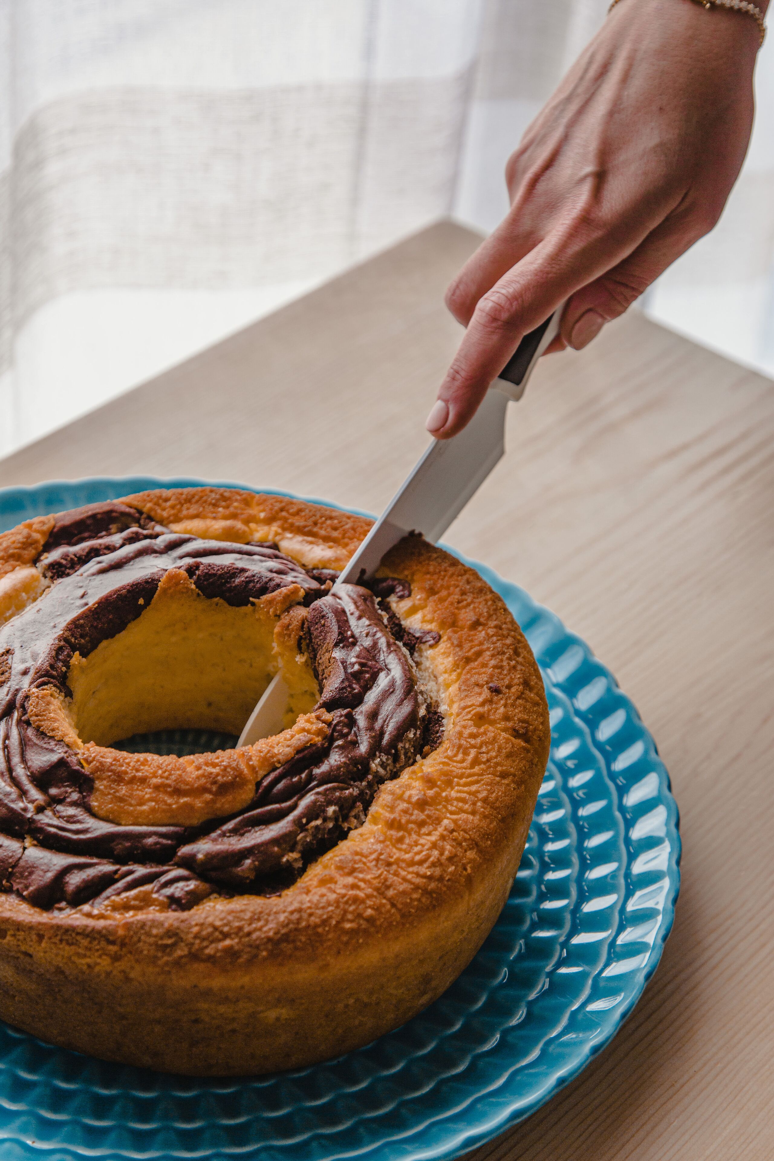 Un pastel con glaseado de chocolate sobre un plato azul.