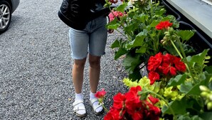 A person holding a watering can near a building with large windows and a gravel driveway. - Kinna Bed & Breakfast (Kinna)