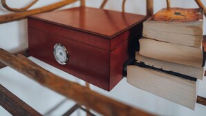 Une chaise en bois avec une boîte rouge et des livres dessus.
