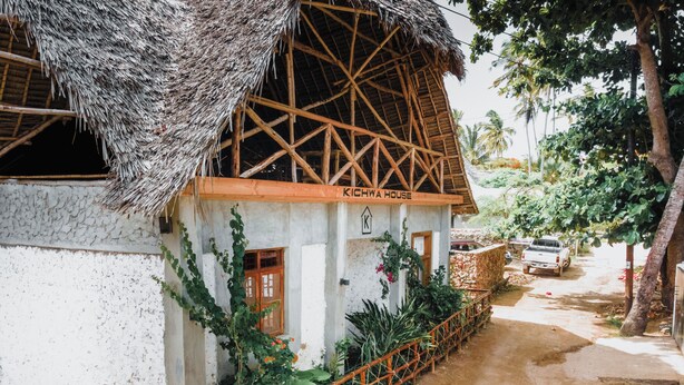 Une maison traditionnelle avec un toit de chaume et une charpente en bois, appelée « Kichwa House ».