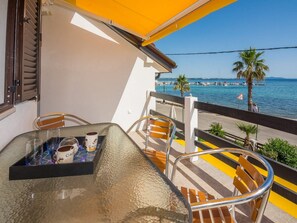 A balcony with a table, chairs, and a view of the sea. - Apartments Sea Eyes (Vir)