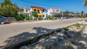 Una calle costera con edificios, un café y una señal de tráfico.