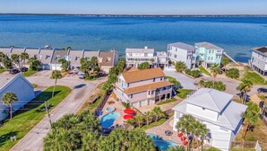 A coastal residential area with houses, a swimming pool, and a view of the ocean.