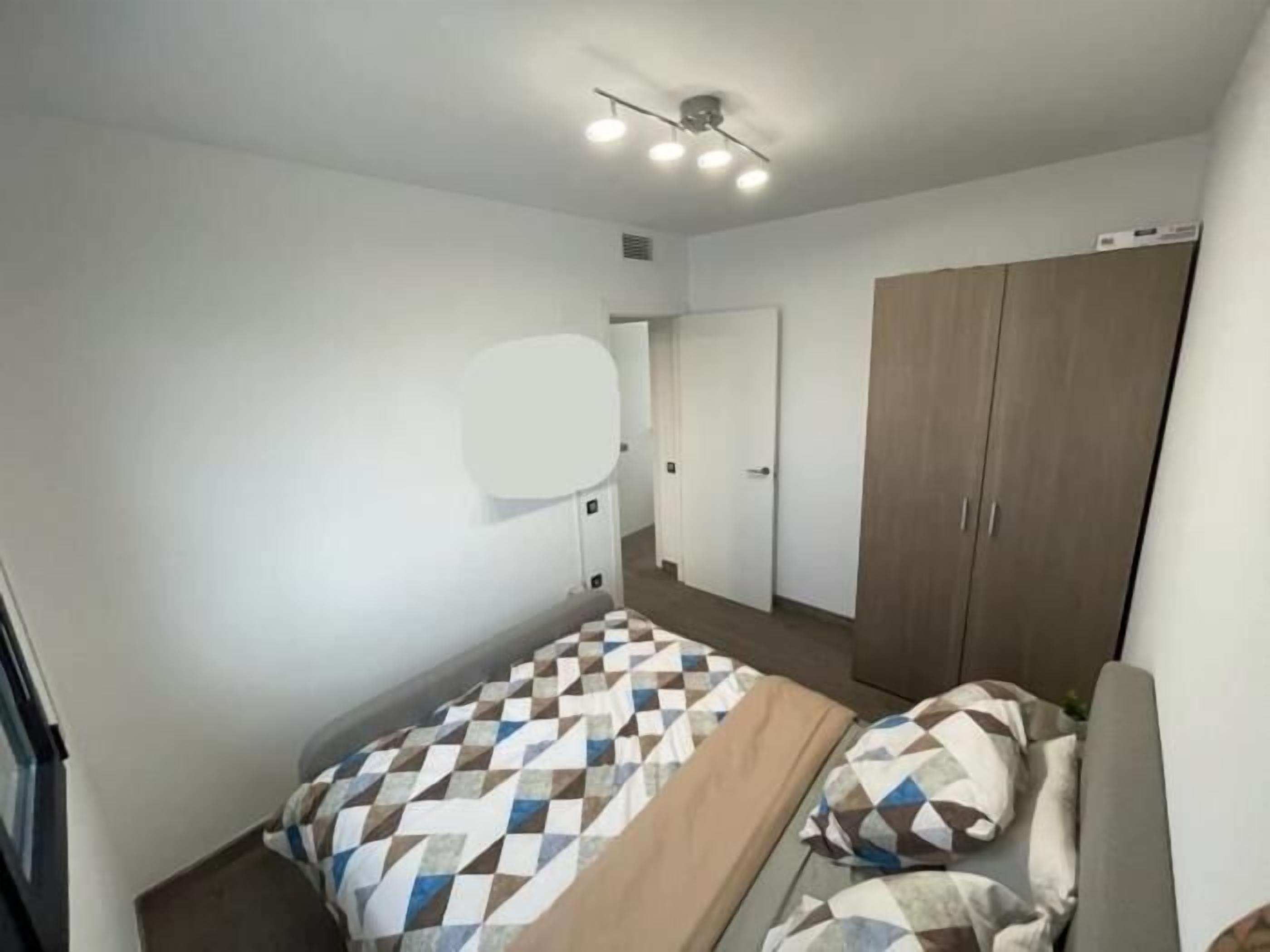 Une chambre à coucher avec un lit, une armoire et un miroir.