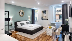 Un dormitorio moderno con una cama grande, una mesita de centro de mármol, un televisor y vistas al exterior.