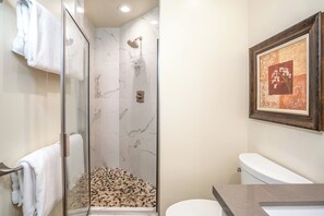 A bathroom with a glass-enclosed shower, a toilet, and a framed artwork on the wall. - Palms at Wailea #1207 Ground Floor Unit, Near Complex Pool and Shared Hot Tub (Wailea)
