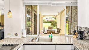 A modern kitchen with a granite countertop, stainless steel sink, and a built-in stove. - Palms at Wailea #1207 Ground Floor Unit, Near Complex Pool and Shared Hot Tub (Wailea)
