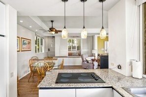 A modern kitchen with granite countertops, a built-in stove, and pendant lighting.