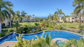 A resort with a swimming pool, palm trees, and a view of the ocean. - Palms at Wailea #1207 Ground Floor Unit, Near Complex Pool and Shared Hot Tub (Wailea)