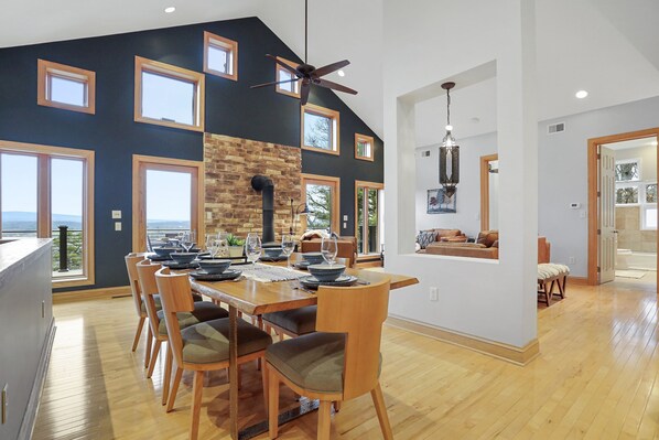 Un comedor espacioso con techo alto, ventanas amplias y vistas al exterior.