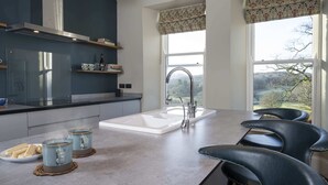 A modern kitchen with a large island, a built-in sink, and a view of the outdoors. - The Old Vicarage,  Country Retreat by LetMeStay (Ambleside)