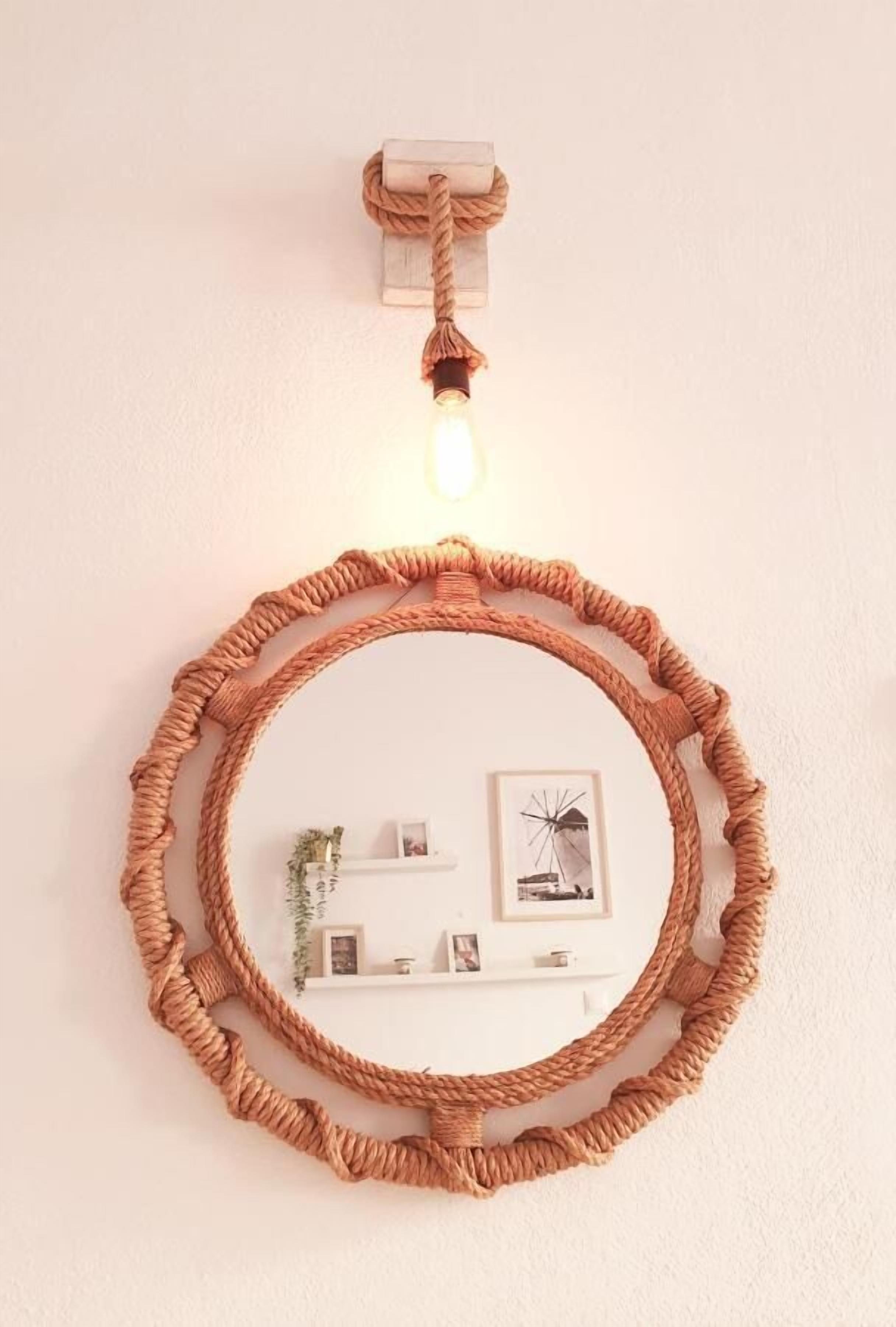 A circular rope wall hanging with a light fixture above it, and a small shelf with decorative items below.