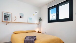 Un dormitorio con cama, ventana y adornos en la pared.