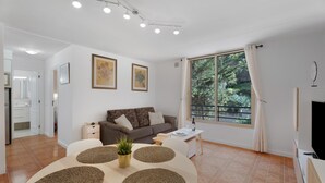 Una sala moderna con sofá, mesa de centro y comedor con individuales.