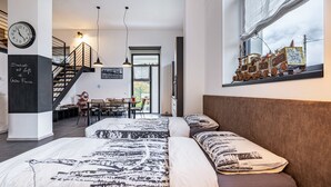Ein modernes Schlafzimmer mit einem Bett, einem Schreibtisch und einer Treppe.