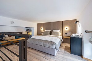 A modern bedroom with a bed, bedside tables, a nightstand, and a built-in wardrobe. - Loft "Casa Facco" with Mountain View, Garden & Wi-Fi (Bocenago)