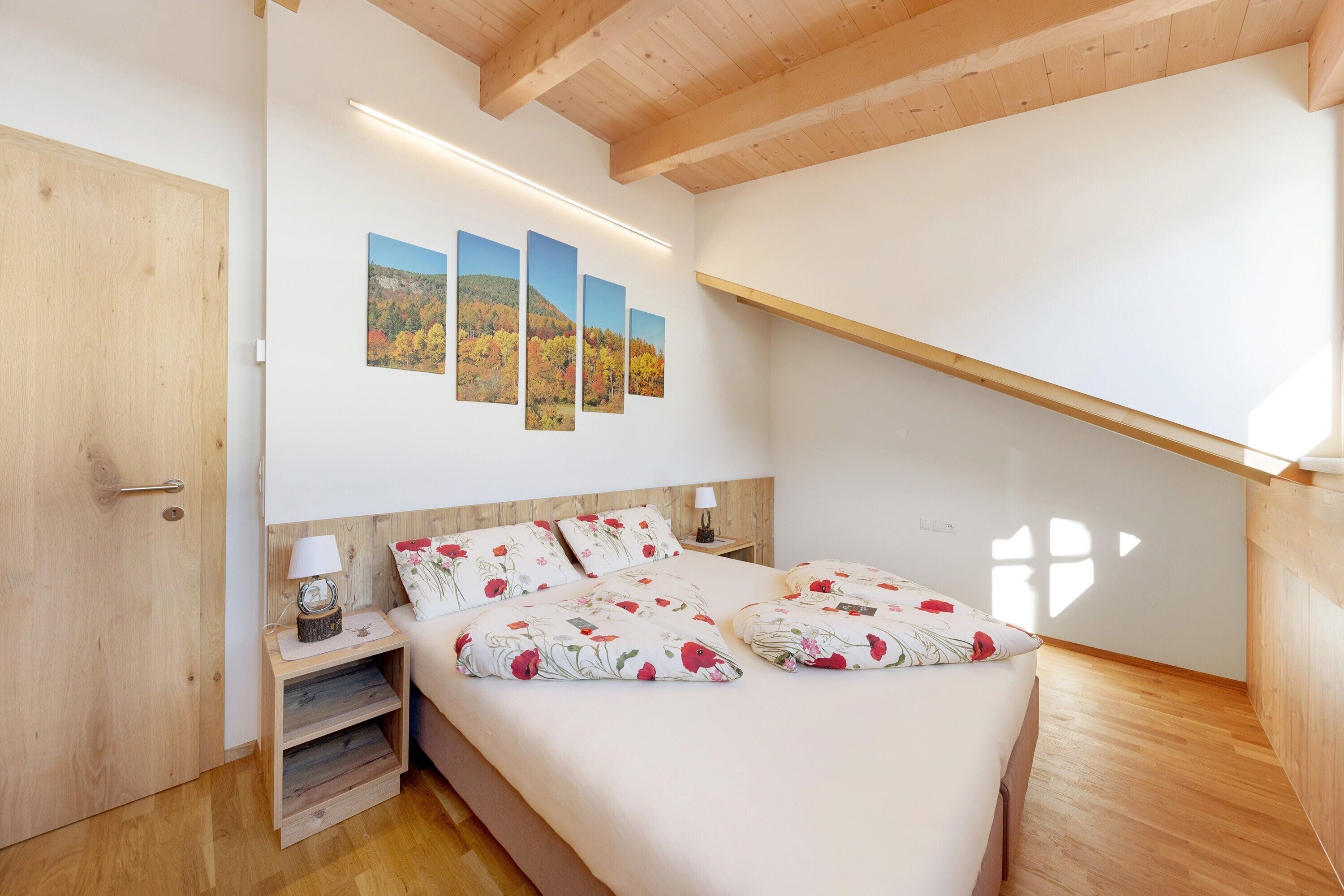 Een slaapkamer met een bed, een houten hoofdbord, nachtkastjes en een wandplank.