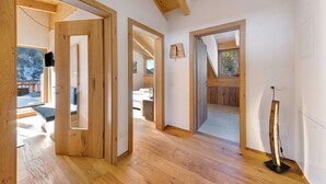 A spacious room with wooden floors, a large window, and a view of a snowy landscape. - Töniglerhof  "Apartment Morgensonne" with Mountain View, Garden & Wi-Fi (Trodena)