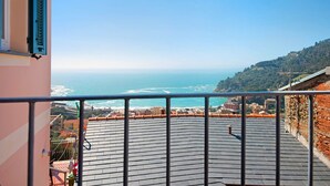 Un balcon avec vue sur la mer et une ville côtière.
