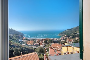 A coastal town with buildings, a view of the sea, and a clear sky.