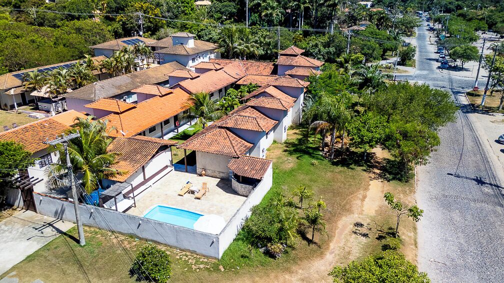An aerial view of a residential area with multiple houses, a swimming pool, and a road.