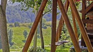 A rustic wooden structure with a brick wall and a view of a lush green landscape. - Andrea in Sertić Poljana  - Haus für 6 Personen (Plitvička jezera)