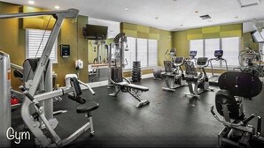 A gym with various exercise equipment, including treadmills, stationary bikes, and weight machines.
