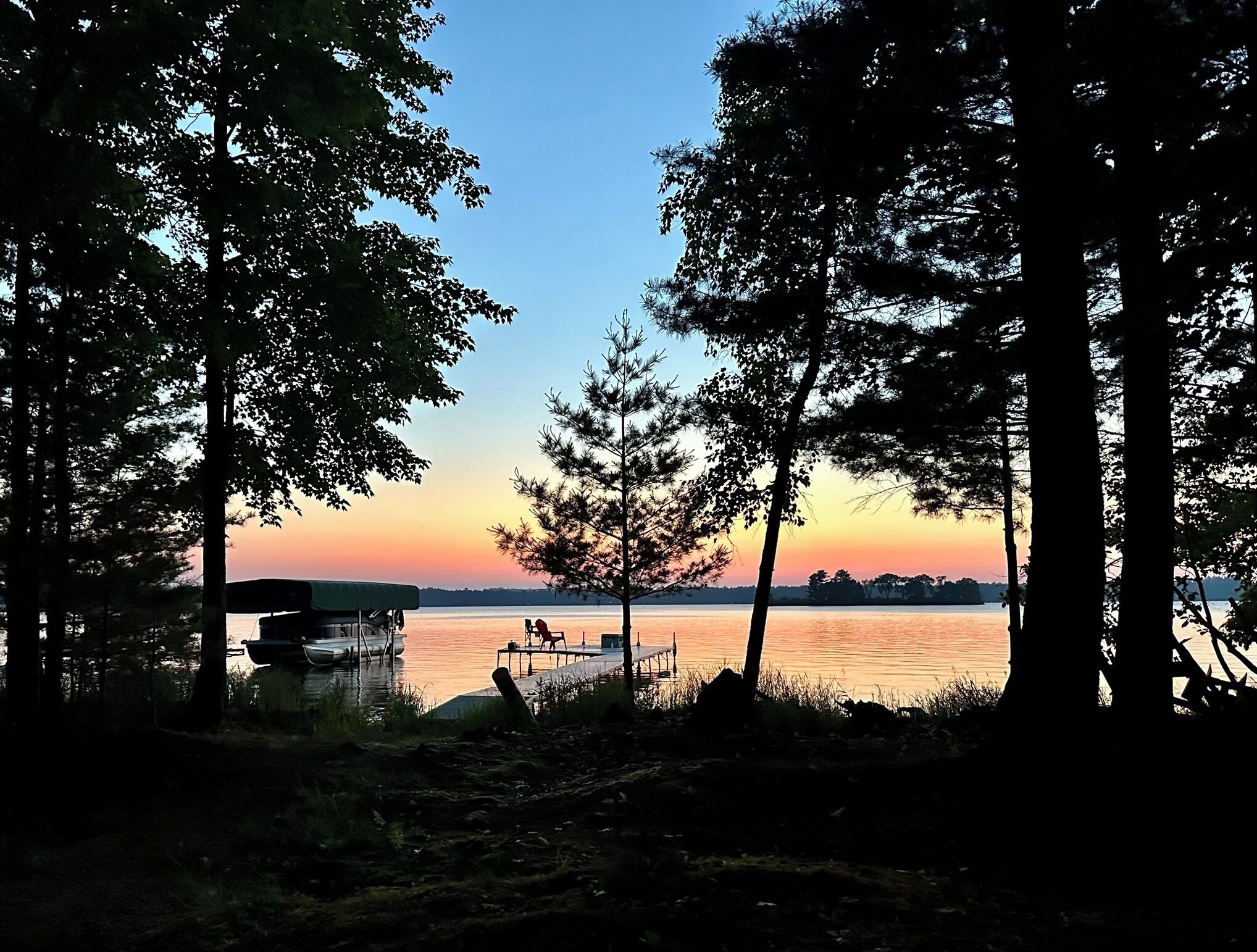 Une vue sur le lac, avec un quai et un abri pour bateaux.