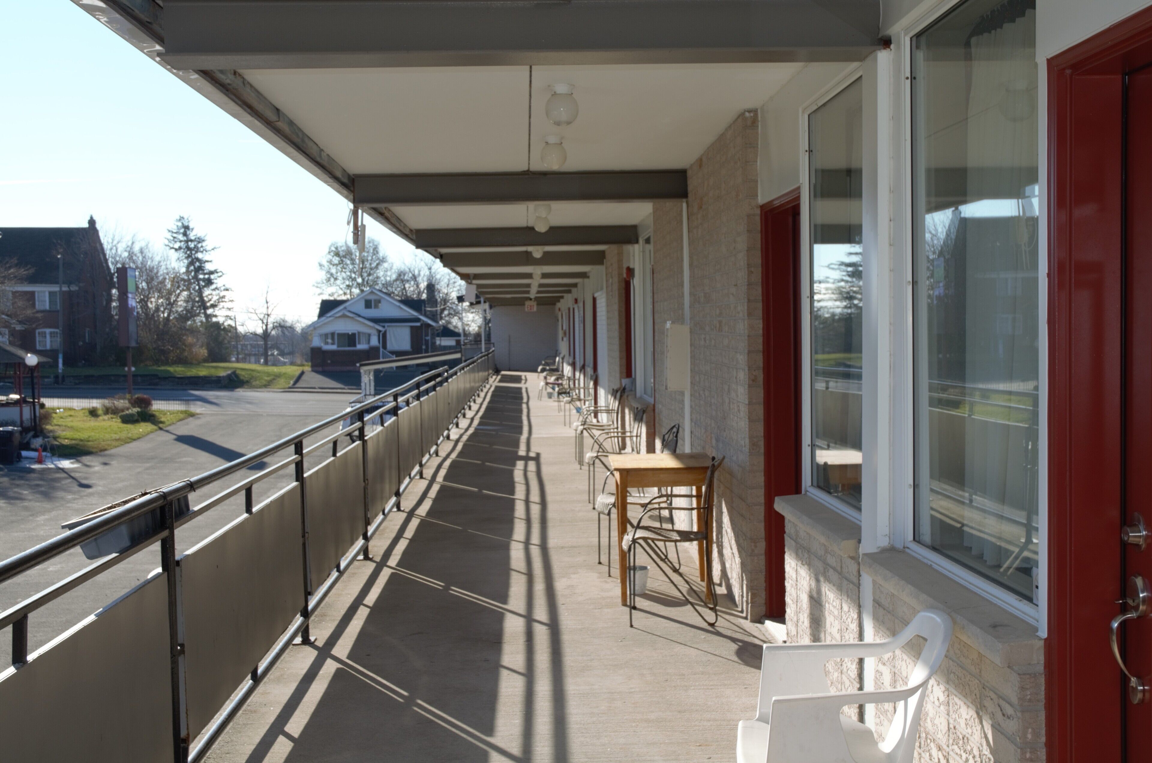 Un balcon extérieur abrité, doté d’une rambarde, d’une table et de chaises.