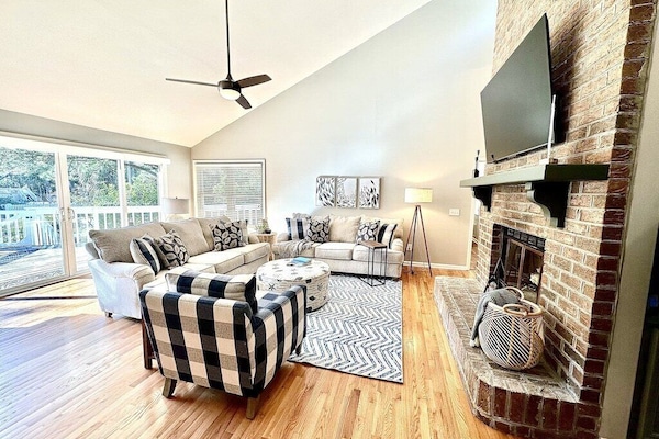Open living room with ample seating, a fireplace, and a flat-screen television.