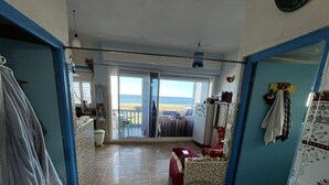 A room with a view of the beach, a dining area, and a kitchen. - Superb apartment in Targha, 100 m from the beach<br>15 km to oued law<br>5 km to karasras (Tétouan)