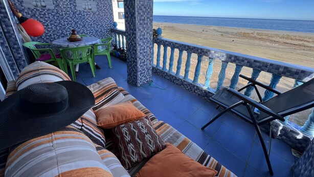 A covered outdoor seating area with a view of the beach. - Superb apartment in Targha, 100 m from the beach<br>15 km to oued law<br>5 km to karasras (Tétouan)