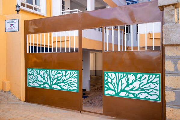 A gated entrance with a metal gate and a tree decal.
