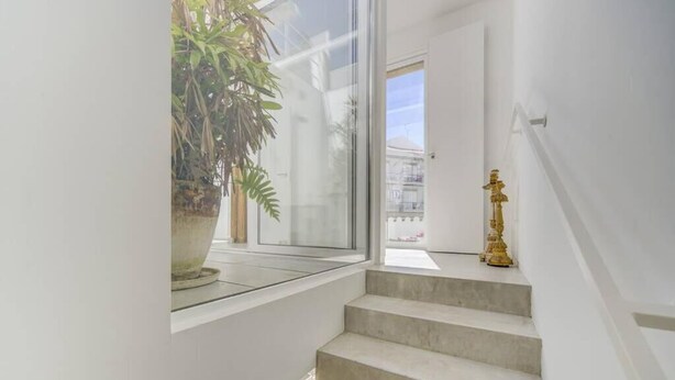 A staircase with a potted plant on the landing and a decorative item on the wall. - Charming architect-designed house in the heart of Tavira (Tavira)