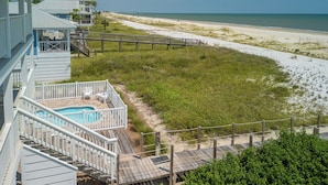 A beachfront property with a swimming pool, wooden deck, and a view of the beach and ocean. - Gulf-front, private pool, pets welcome! (Port Saint Joe)
