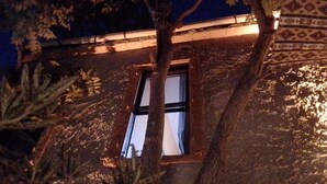 A building with a window and a tree in front. - Titan House Hostel (Izmir)