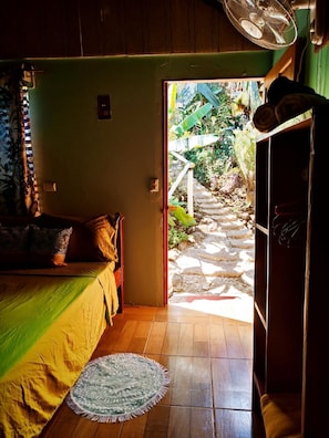 Relax in this inviting room with a comfortable bed, wooden wardrobe, and ceiling fan.