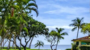 A lush green landscape with palm trees and a view of the ocean.